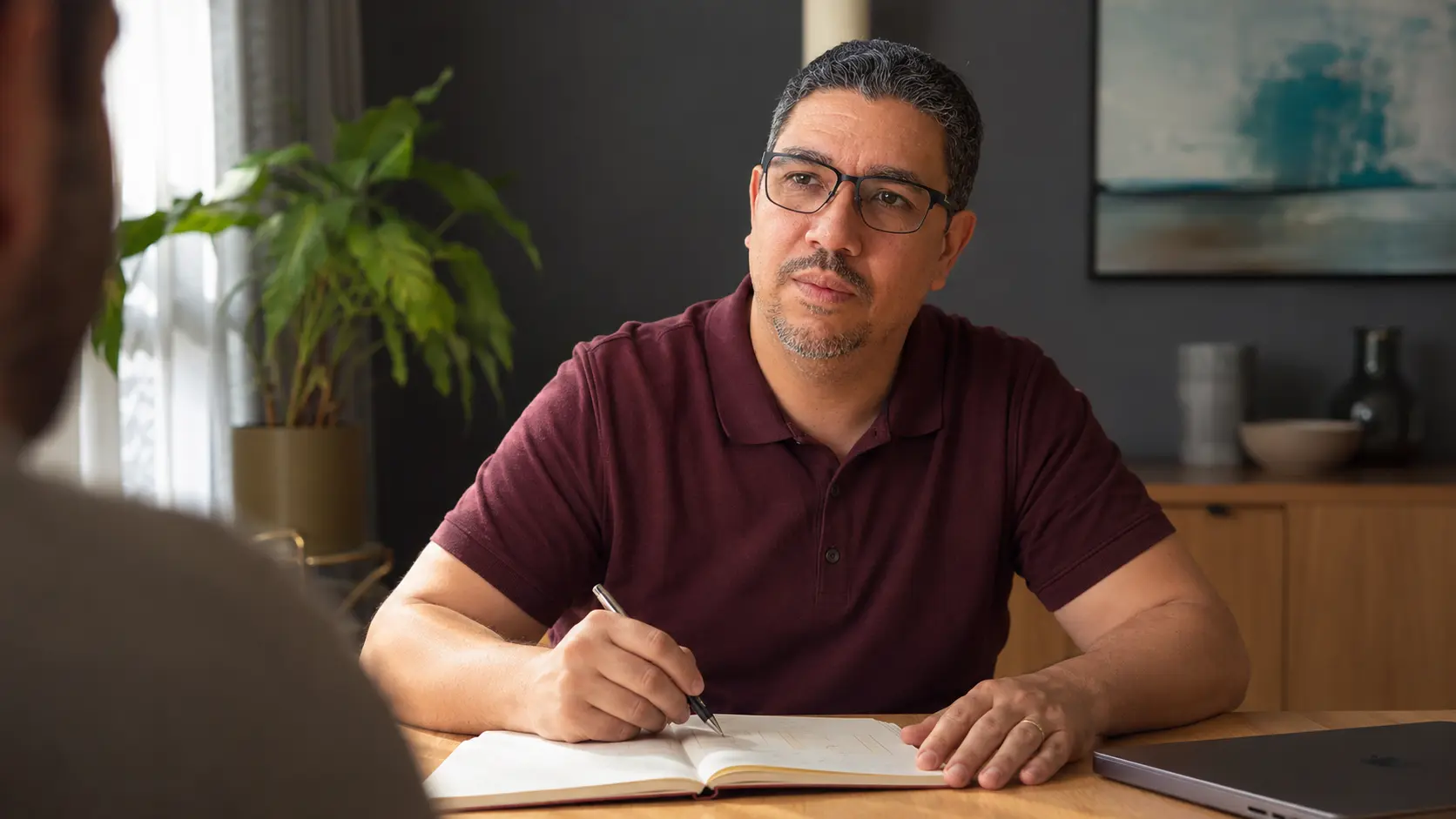 Isaac Andrade ouvindo atentamente uma pessoa durante uma conversa profissional